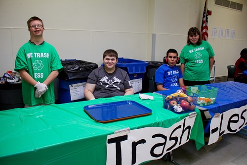 Four students working at the Trash Less Thursdays table in the UAHS cafeteria