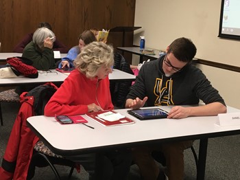A student helping a resident during the first Teen Tech Help event