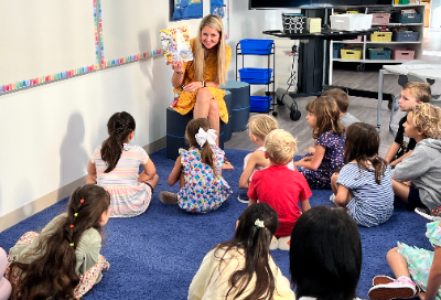 An elementary teacher reading the book "First Day Jitters" to her class