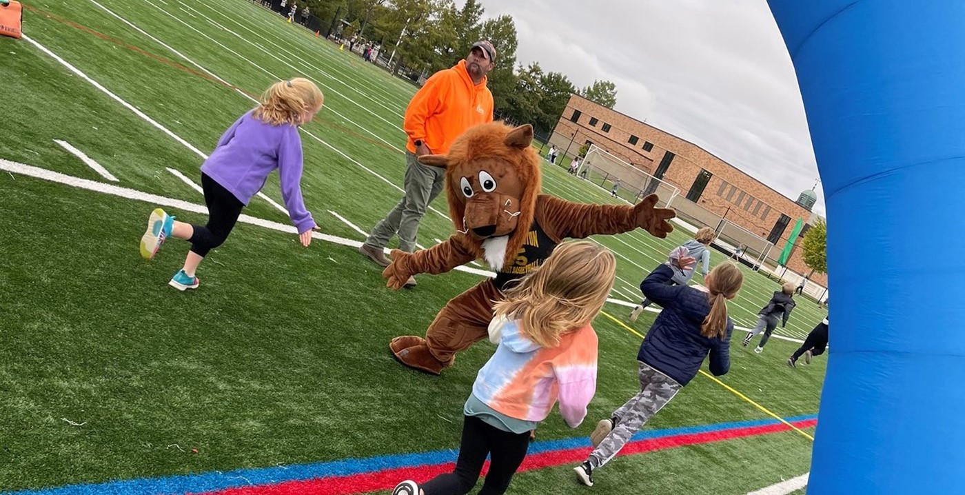 Students high-fiving the Tremont mascot during the walkathon