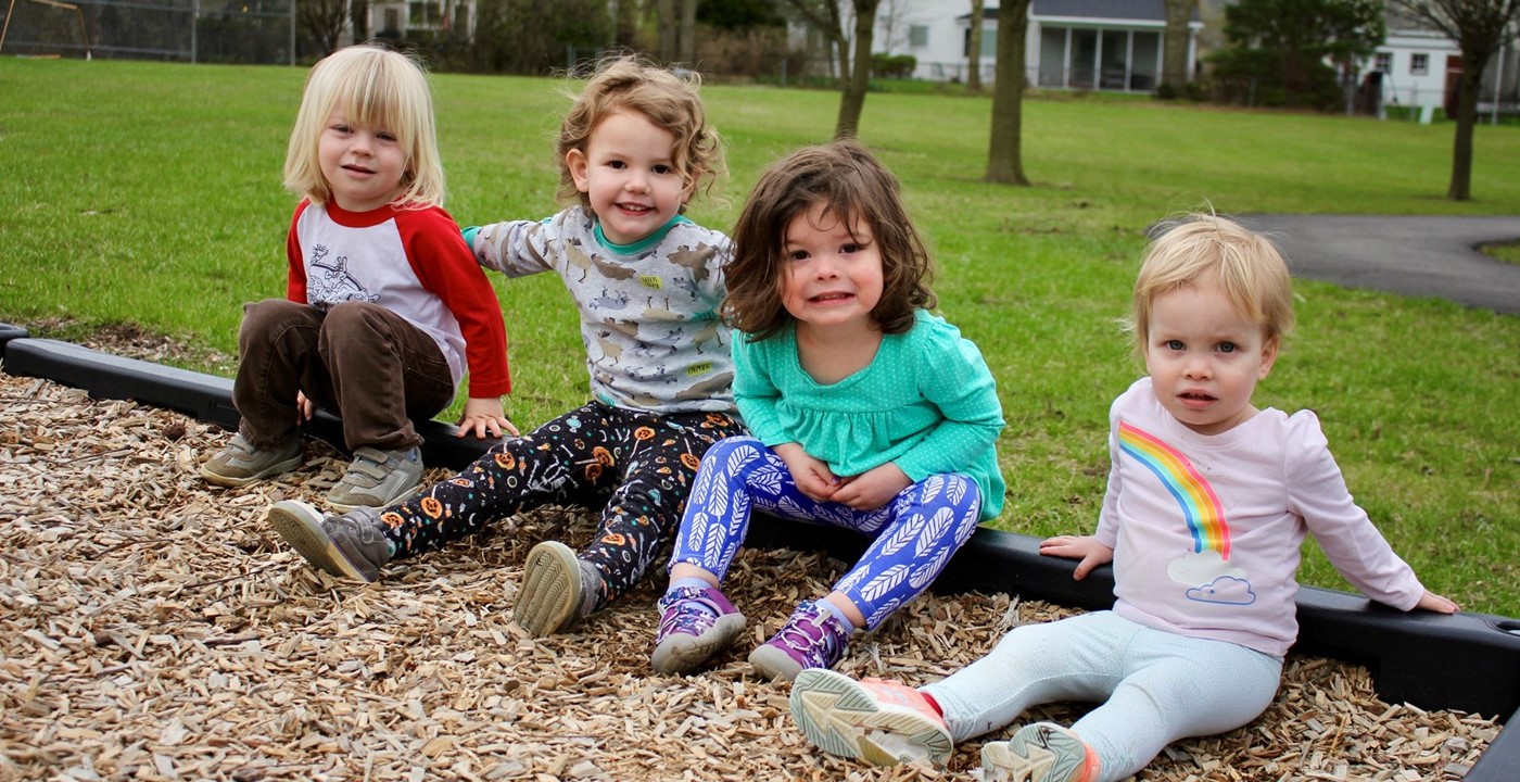 Four young preschoolers smiling for a photo