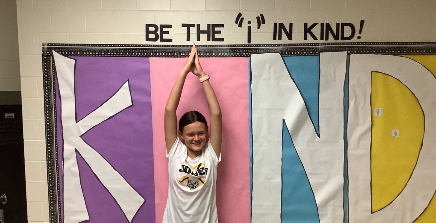 A student posing as the &#34;i&#34; for a Be the &#34;i&#34; in kind bulletin board