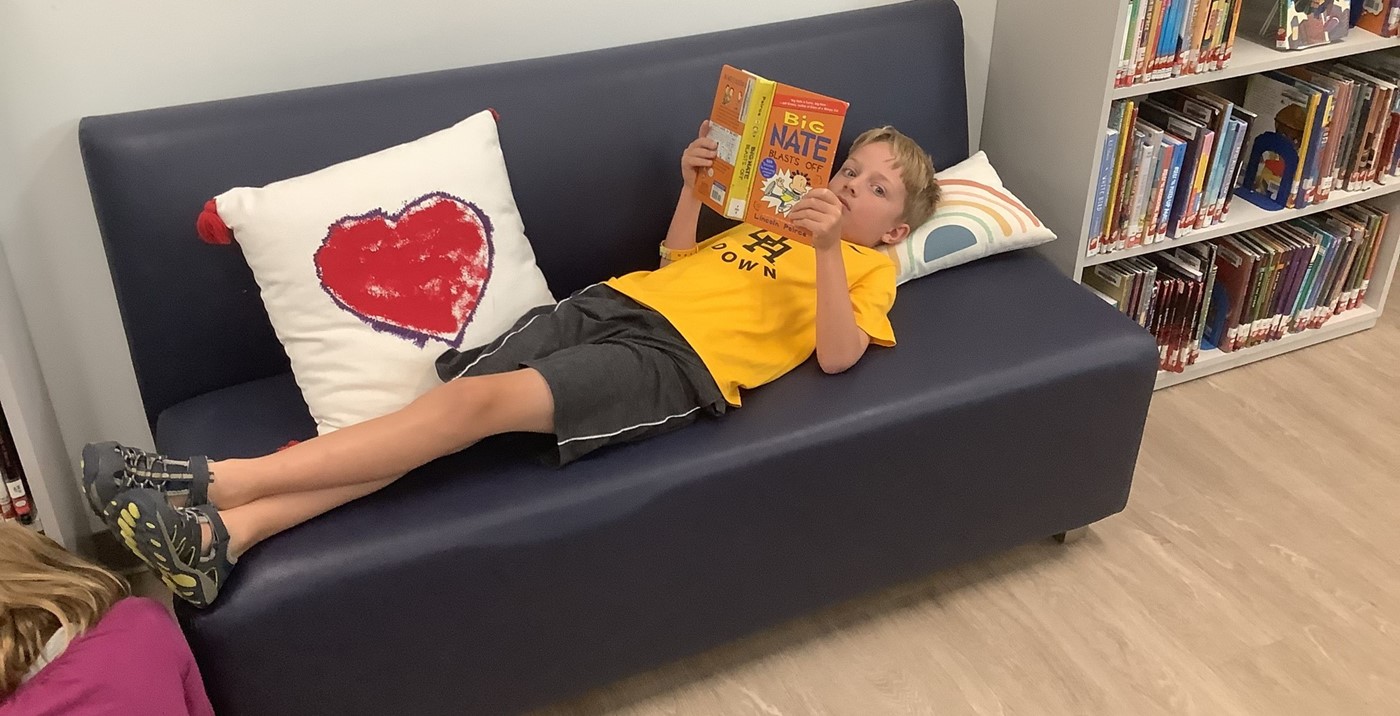 Student reading on couch in library