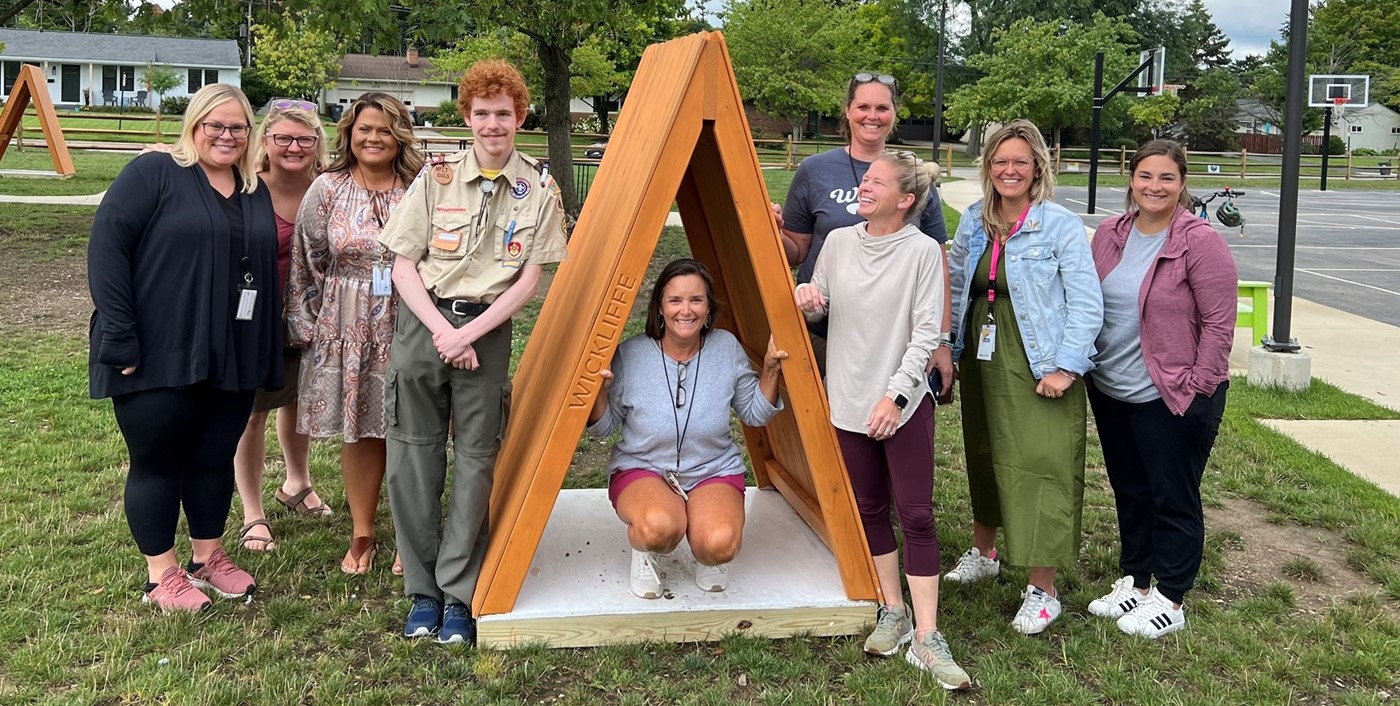 Staff members with Eagle Scout project on playground